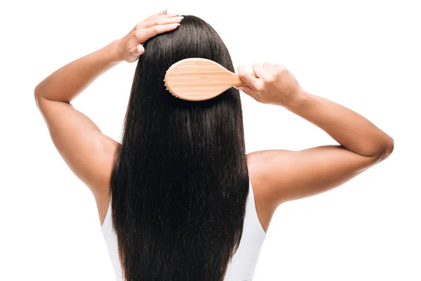 Visão traseira da morena bela mulher escovando cabelos longos, retos, saudáveis e brilhantes com pente isolado no branco — Fotografia de Stock