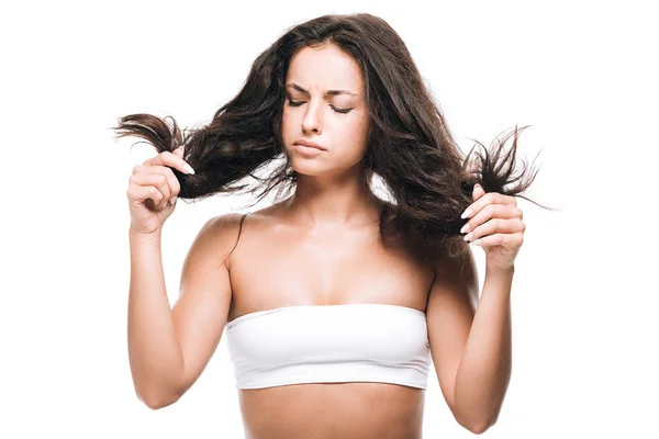 Triste brunette belle femme regardant les cheveux bouclés isolé sur blanc — Photo de stock