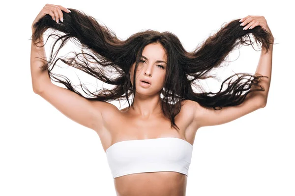 Брюнетка красива жінка тримає хвилясте волосся ізольовано на білому — стокове фото