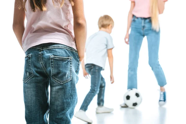 Cropped view of mother and son playing with football near kid on white — Stock Photo