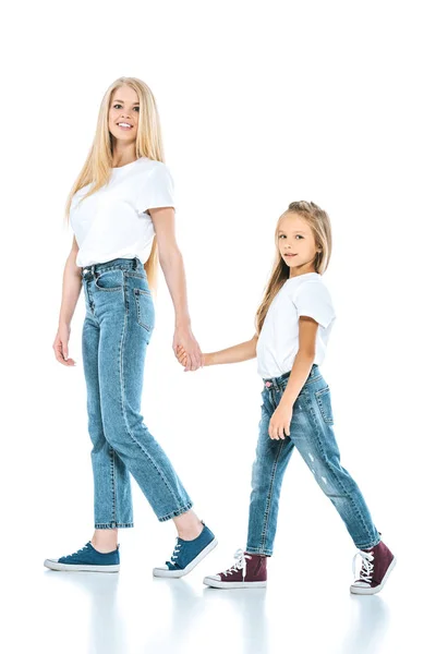 Mother and daughter holding hands while walking on white — Stock Photo