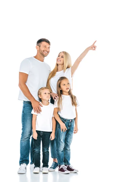 Happy woman looking at husband while pointing with finger near kids on white — Stock Photo