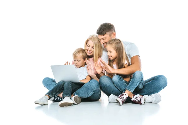 Positive parents looking at laptop and waving hands with kids on white — Stock Photo