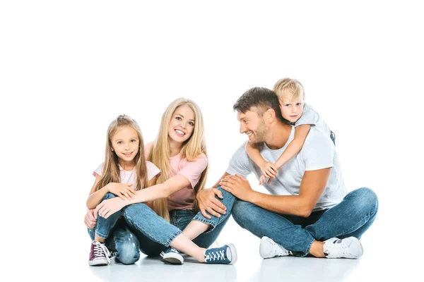 Щасливі батьки і діти в блакитних джинсах сидять на білому — стокове фото