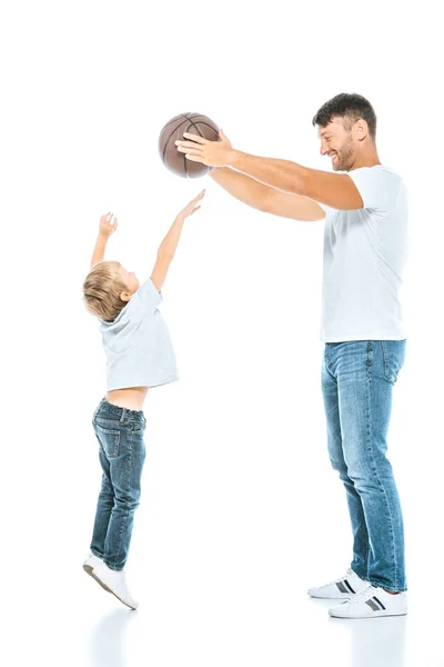 Uomo allegro che tiene il basket vicino al figlio che salta sul bianco — Foto stock