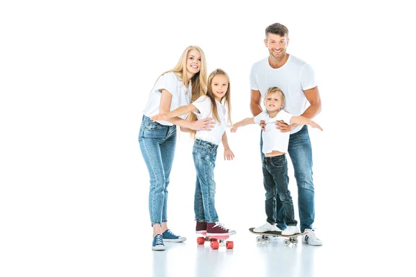 Glückliche Eltern in der Nähe von Kindern, die auf weißen Penny-Brettern reiten — Stockfoto