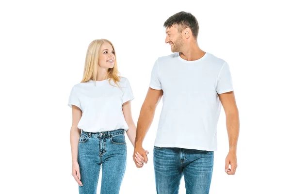 Hombre feliz cogido de la mano con la mujer y sonriendo aislado en blanco - foto de stock