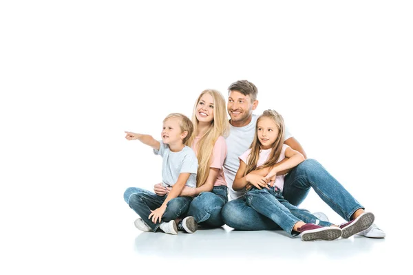 Happy boy pointing with finger near sister and parents on white — Stock Photo