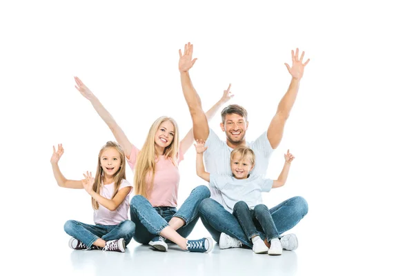 Família feliz com as mãos acima das cabeças sorrindo no branco — Fotografia de Stock