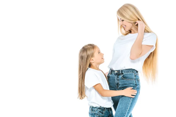 Glückliche Tochter und attraktive Mutter schauen einander isoliert auf weißem Grund an — Stockfoto