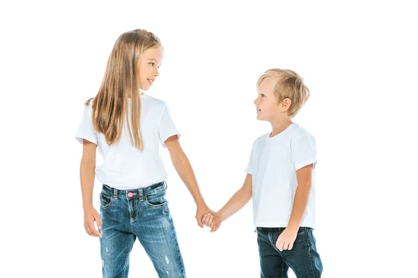 Счастливая сестра и брат в джинсах в джинсах, держась за руки изолированы на белом — стоковое фото