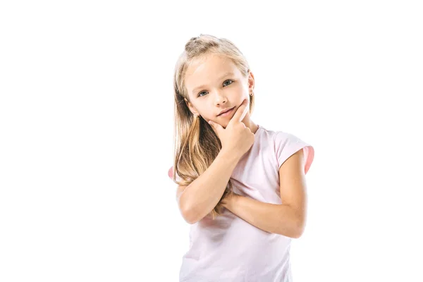Cute and pensive kid touching face and looking at camera isolated on white — Stock Photo