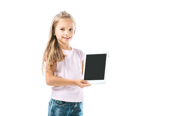 Niño alegre sosteniendo la tableta digital con la pantalla en blanco aislada en blanco - foto de stock