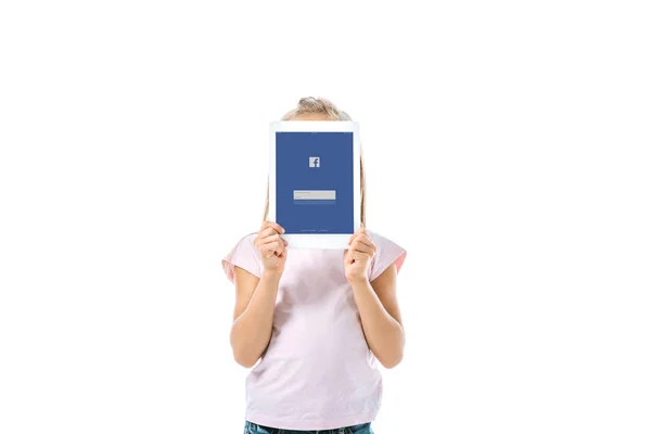 KYIV, UKRAINE - AUGUST 19, 2019: kid covering face while holding digital tablet with facebook app on screen isolated on white — Stock Photo