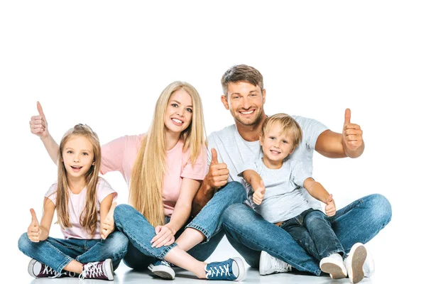 Família feliz sentado e mostrando polegares para cima no branco — Fotografia de Stock