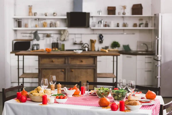 Tisch mit Salat, Gläsern, Kerzen, Gemüse, Pfeffermühle, Mais, Salzmühle und Kürbissen zum Erntedankfest — Stockfoto