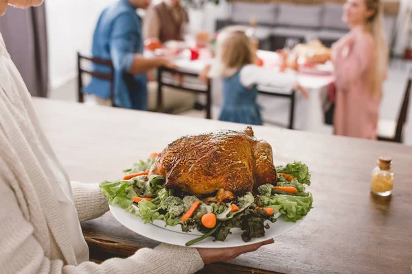 Vista ritagliata della nonna che tiene il piatto con gustoso tacchino nel giorno del Ringraziamento — Foto stock