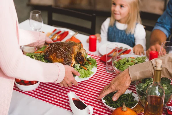 Cropped view of mother holding plate with turkey in Thanksgiving day — Stock Photo