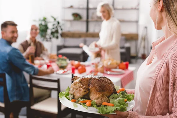 Cropped view of mother holding plate with turkey in Thanksgiving day — Stock Photo