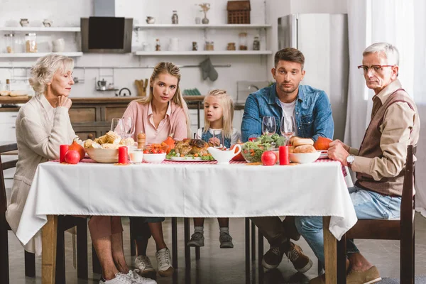 Familiares caucásicos sentados a la mesa en el día de Acción de Gracias - foto de stock