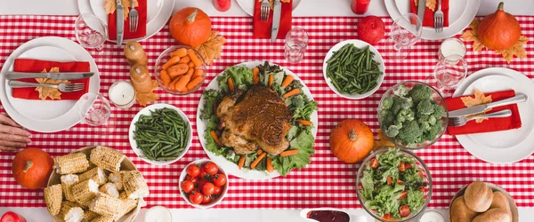 Tiro panorâmico de mesa com salada, copos, velas, legumes, moinho de pimenta, milho, moinho de sal e abóboras no dia de Ação de Graças — Fotografia de Stock