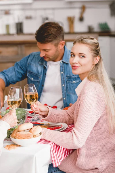 Smiling family members sitting at table and clinking with wine glasses in Thanksgiving day — Stock Photo