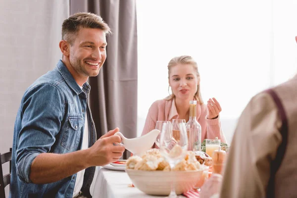 Selektiver Fokus des lächelnden Vaters, der zum Erntedankfest Soße hält — Stockfoto