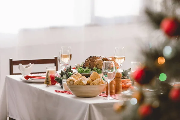 Enfoque selectivo de plato con sabrosas copas de pavo, maíz y vino en la mesa en Navidad - foto de stock