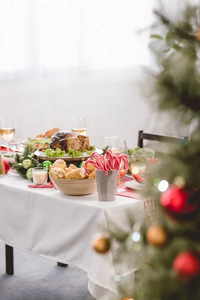 Enfoque selectivo de plato con sabroso pavo, maíz, dulces y copas de vino en la mesa en Navidad - foto de stock
