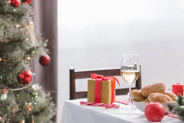 Selective focus of wine glass, pies and christmas gift on table — Stock Photo