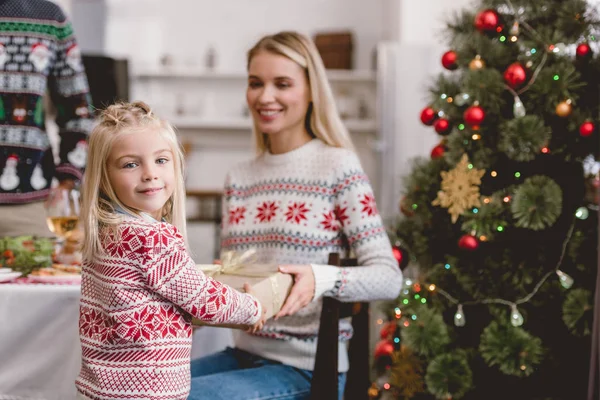 Selektiver Fokus der Mutter, die ihrer Tochter ein Weihnachtsgeschenk macht — Stockfoto