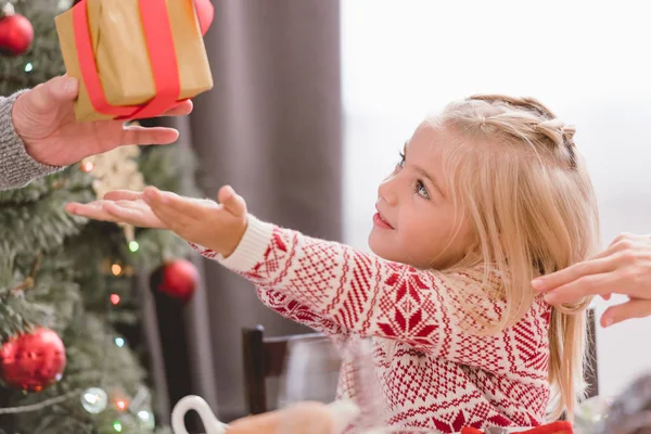 Cropped view of grandfather giving christmas gift to his granddaughter — Stock Photo