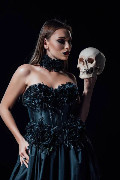 Effrayant vampire fille en noir gothique robe tenant crâne humain isolé sur noir — Photo de stock