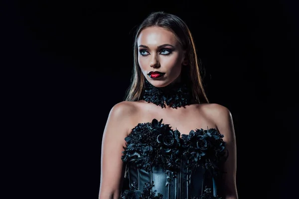 Scary vampire girl in black gothic dress looking away isolated on black — Stock Photo