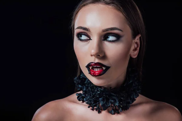 Голая страшная девушка-вампир с клыками, смотрящая в сторону, изолированная от черного — стоковое фото