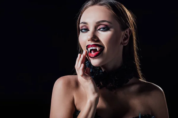 Голая страшная девушка-вампир показывает клыки изолированные на черном — стоковое фото
