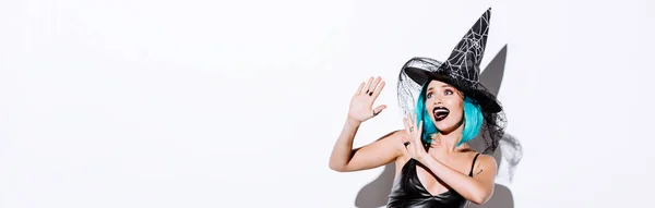 Panoramic shot of girl in black witch Halloween costume with blue hair on white background — Stock Photo