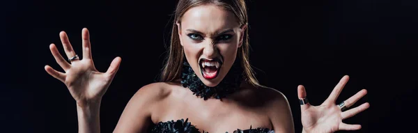 Panoramic shot of scary vampire girl with fangs in black gothic dress isolated on black — Stock Photo