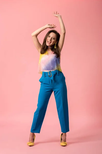 Full length view of happy young stylish disco girl dancing on pink — Stock Photo
