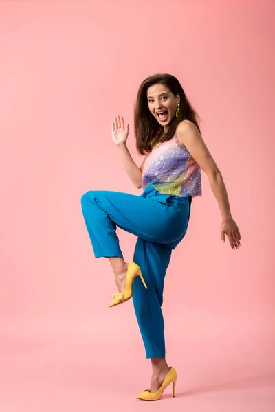 Side view of excited young stylish disco girl dancing on pink — Stock Photo