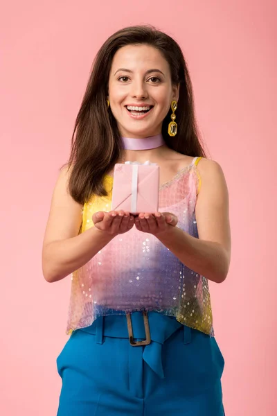 Feliz jovem elegante disco menina segurando caixa de presente isolado em rosa — Fotografia de Stock