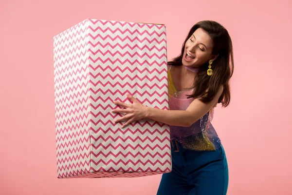 Eccitato giovane ragazza discoteca elegante in possesso di enorme scatola regalo isolato su rosa — Foto stock