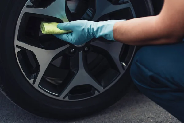 Ausgeschnittene Ansicht von Autoputzer wischt Autorad mit Lappen ab — Stockfoto