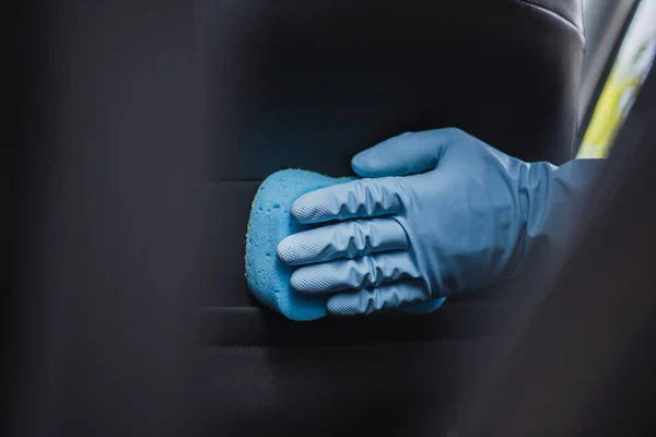 Cropped view of car cleaner washing car seat with sponge — Stock Photo