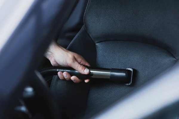 Partial view of car cleaner vacuuming car seat — Stock Photo