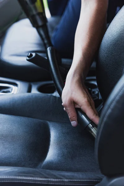 Vue recadrée du nettoyeur de voiture aspirant siège des conducteurs dans la voiture — Photo de stock