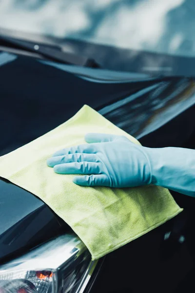 Cropped view of car cleaner wiping car with rag — Stock Photo
