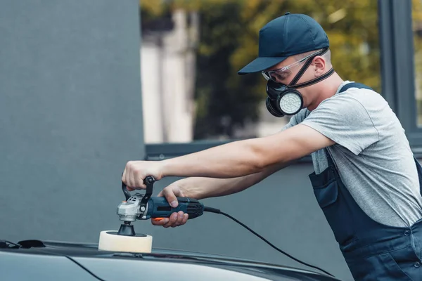 Young car cleaner polishing car with polish machine — Stock Photo