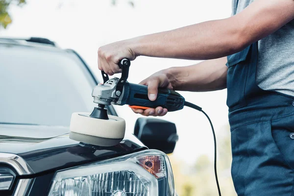 Cropped view of car cleaner polishing car with buffer machine — Stock Photo
