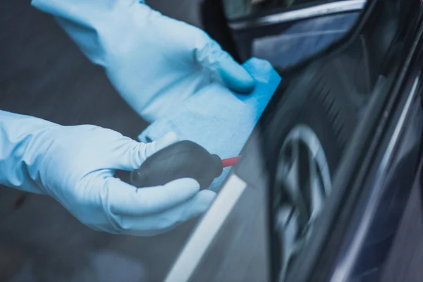 Cropped view of car cleaner dusting car with rubber ait blower — Stock Photo